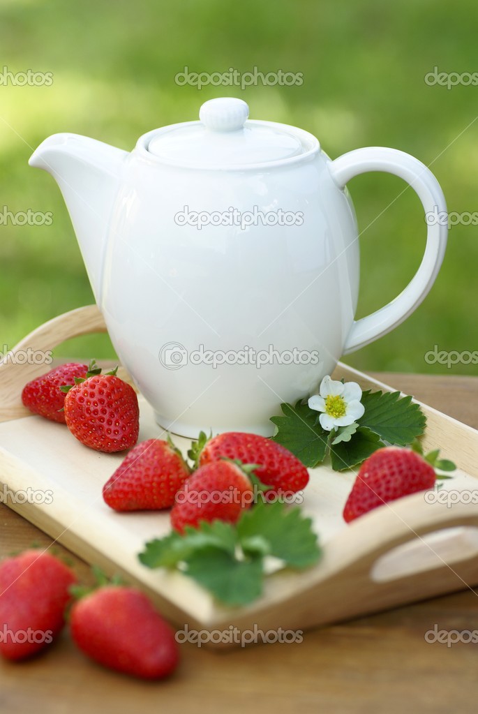 Jug with tea or coffee and strawberries