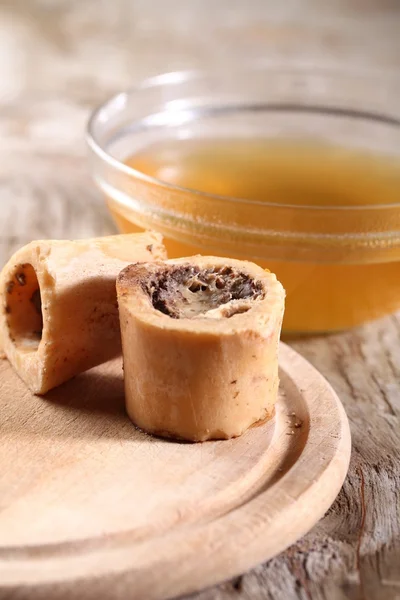 Tigela com caldo de carne e ossos cozidos . — Fotografia de Stock