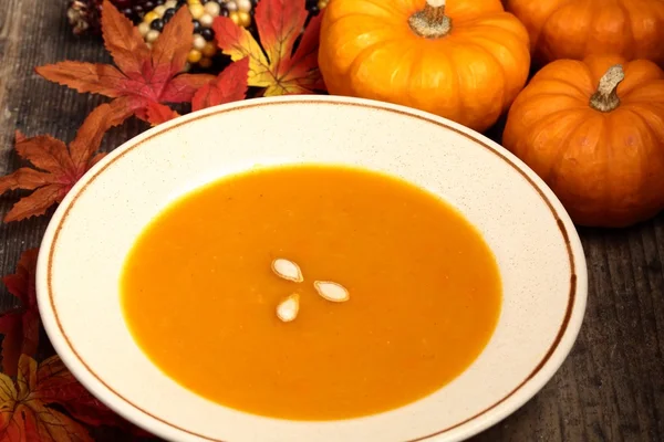 Plate with pumpkin soup and autumn decorations. — Stock Photo, Image