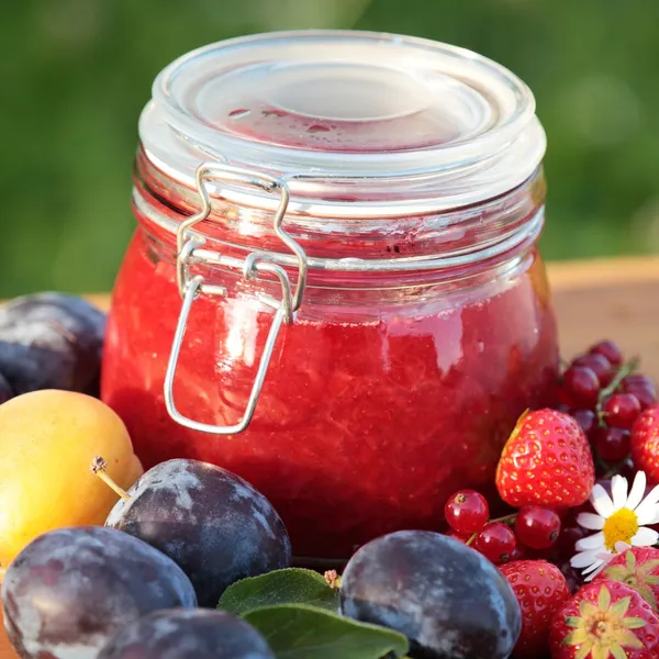 Vaso con marmellata fresca e frutta in giardino — Foto Stock