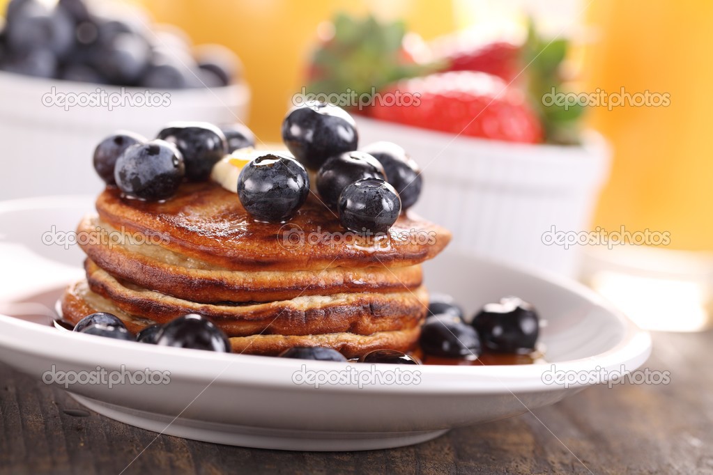 Stack of pancakes with fruits and orange juice