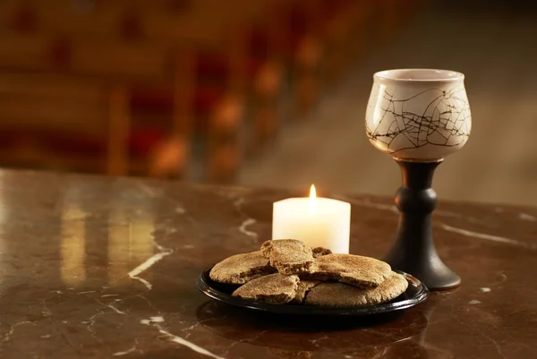 Kelk met wijn en stukje van het brood in de kerk — Stockfoto