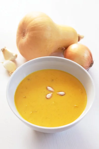 Bowl with pumpkin soup and ingredients. — Stock Photo, Image