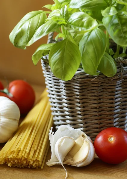 Fresh basil in flowerpot, pasta tomatoes and garlic. — Stock Photo, Image