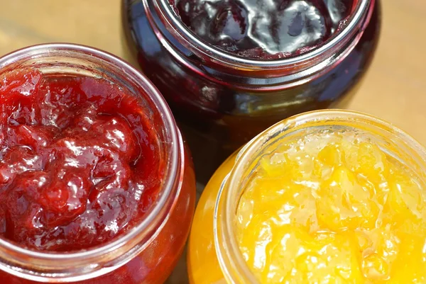 Glas met aardbei, balck bessen en perzik jam. — Stockfoto