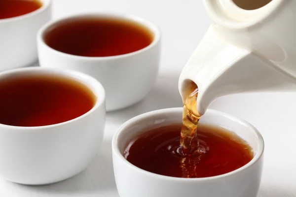 Tea cups and pouring black tea. — Stock Photo, Image