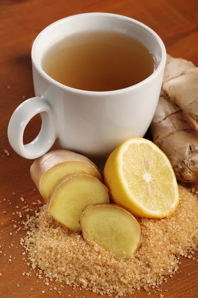 Cup of ginger tea and fresh ingredients — Stock Photo, Image