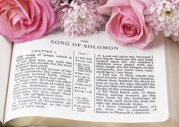 Svatá bible otevřela na píseň Šalamounova a květiny. — Stock fotografie