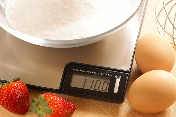 Kitchen scale with bowl with sugar and eggs — Stock Photo, Image