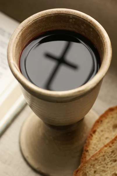 Chalice with wine, piece of bread and open Bible. — Stock Photo, Image