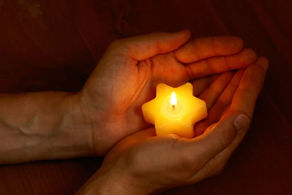 Dettaglio delle mani con candela accesa — Foto Stock