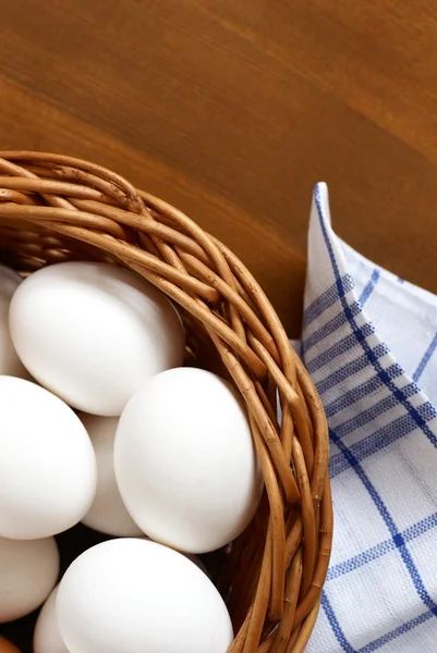 Cesta de vime com ovos de galinha e pano de prato . — Fotografia de Stock