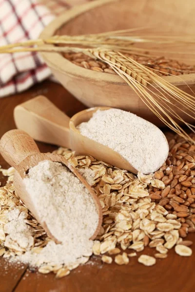 Farina integrale su cucchiai di legno, avena e mais . — Foto Stock