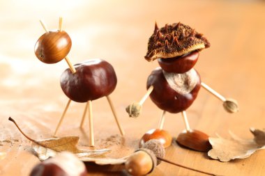 ahşap masa üstünde kestane ve meşe palamudu figürler.