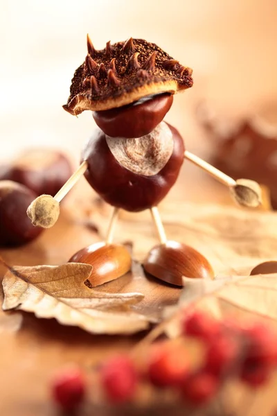 Chestnut and acorn figurine on wooden table. — Stock Photo, Image
