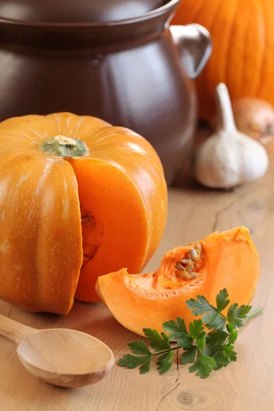 Pezzo di zucca, prezzemolo, aglio, cipolla e pentola da cucina . — Foto Stock