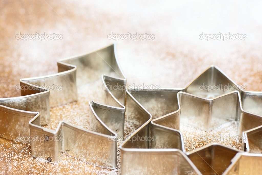 Cookie cutters on white flour or sugar background