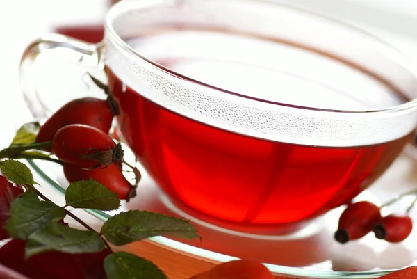 A csipkebogyó tea és a gyümölcs az asztalra kupa — Stock Fotó