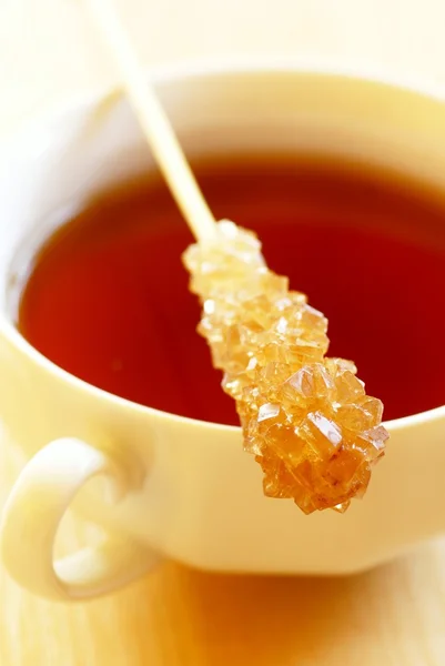 Taza de té y palillo con azúcar morena — Foto de Stock