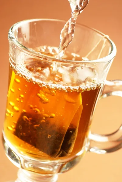 Üveg tea a teás zacskó és a zuhogó víz. — Stock Fotó