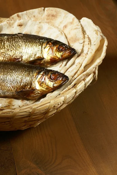 Pani di pane e due pesci in un cesto — Foto Stock