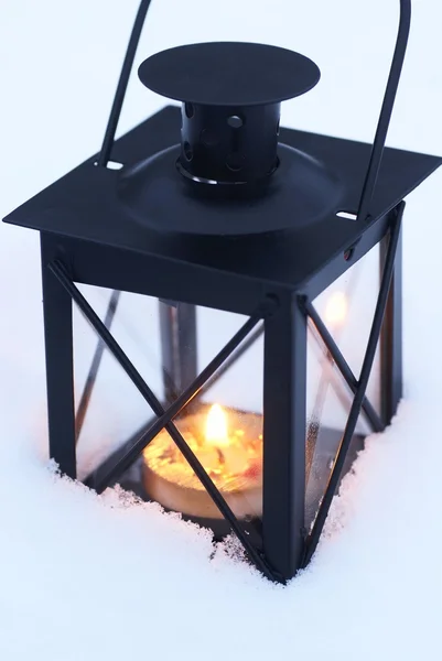 Lucerna s hořící svíčkou na sněhu — Stock fotografie