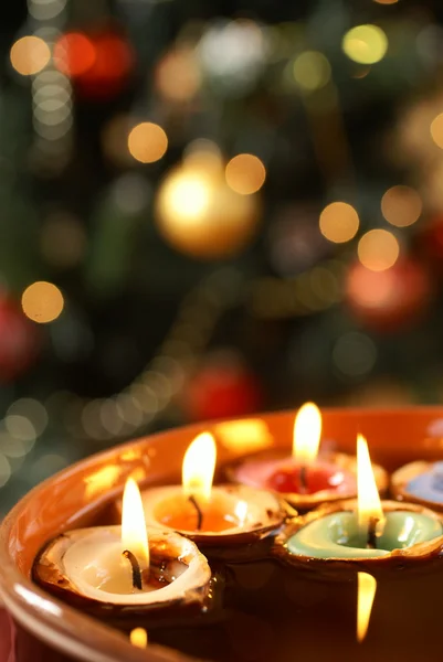 Kerzen in Nussschalen schwimmend auf Wasser mit weihnachtlichem Hintergrund. — Stockfoto