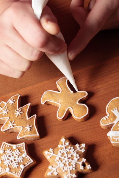 Närbild av händer med pepparkakor cookie och pipping väska — Stockfoto