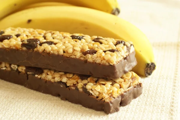 Detail of granola bars, bananas and chocolate — Stock Photo, Image