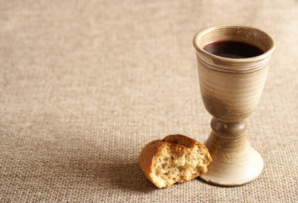 Chalice with wine and bread. Background with copy space