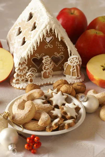 Gingerbread house, christmas cookies and apples — Stock Photo, Image