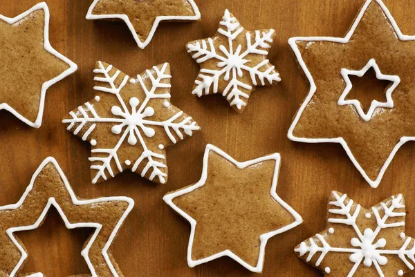Various gingerbread stars on wooden background — Stock Photo, Image