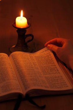 Bible and candle in dark