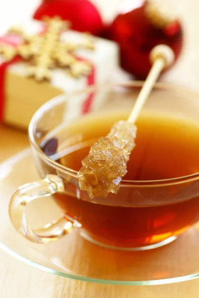 Чашка чая с коричневой сахарной палочкой — стоковое фото