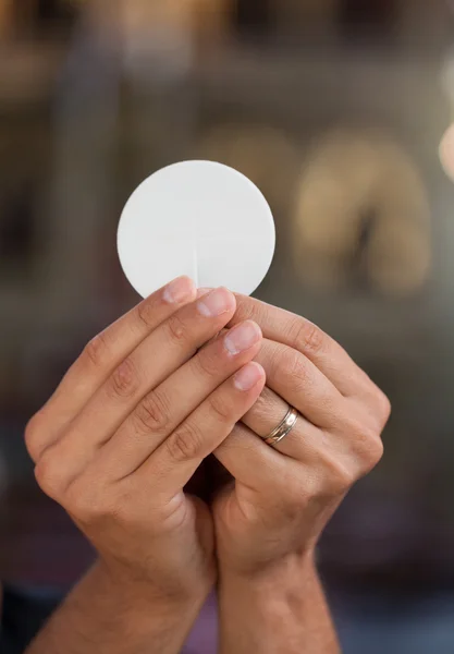 Hands with bread for holy communion. — Stock Photo, Image