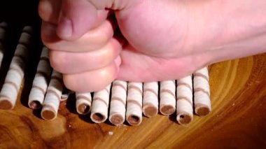 Bir yumruk çikolata kremalı gofretleri kırar. Yakın plan..