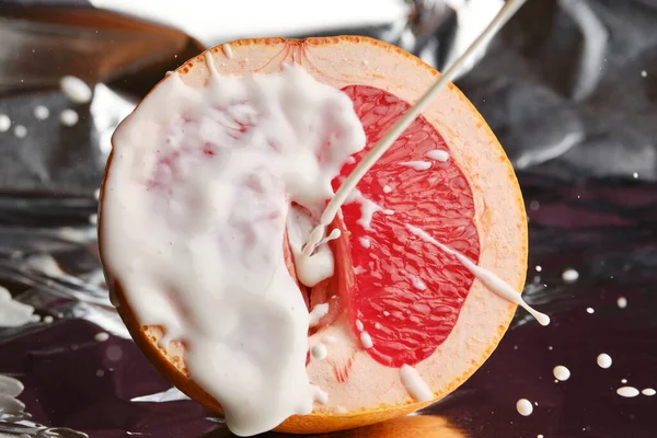 Half a grapefruit and a splash of yogurt. Erotic concept. A symbolic image of a vagina and sperm. Unprotected sex. Close-up. Selective focus