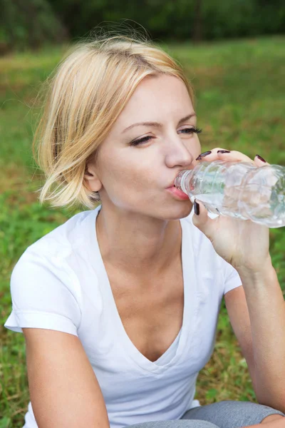 Ung frisk kvinna dricker vatten från flaska. — Stockfoto