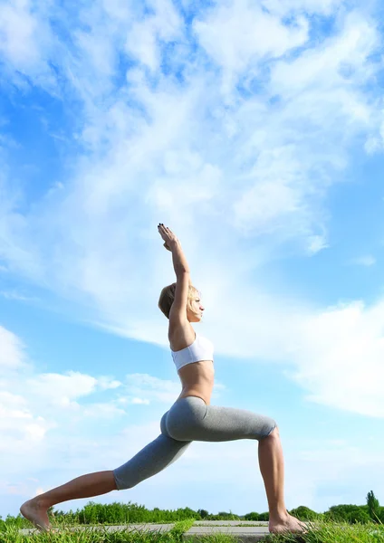 Kobieta praktykowania jogi wojownik stanowią. — Zdjęcie stockowe