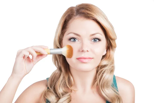 Beautiful woman with Makeup Brush. Young blonde girl is holding make up brush near her pretty face. White background. Studio shot — Stock Photo, Image