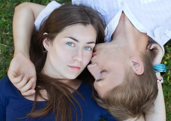 Romantiska lyckliga unga par i kärlek avkopplande på gräset — Stockfoto