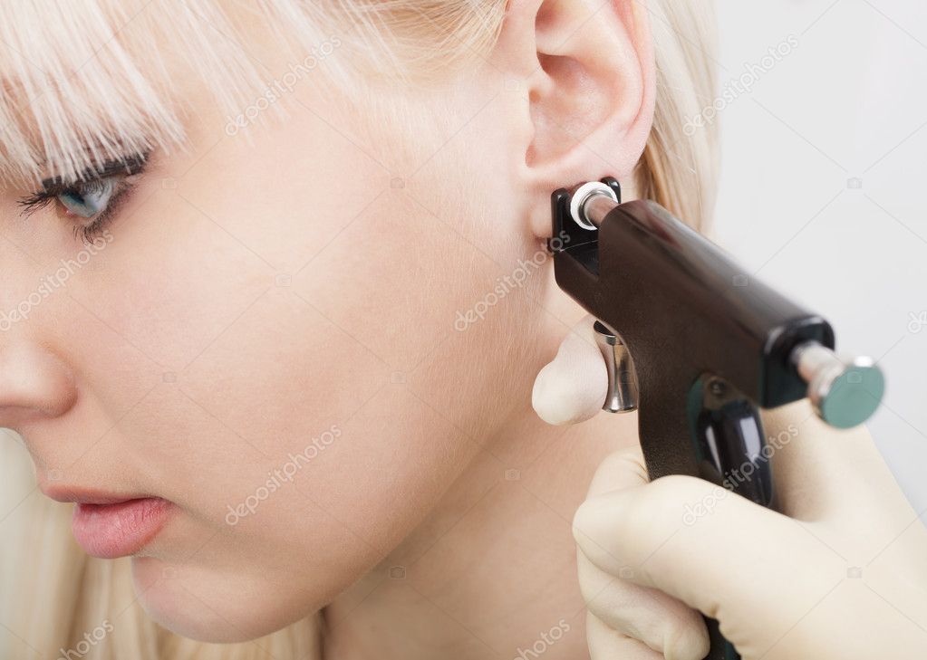 Woman having ear piercing