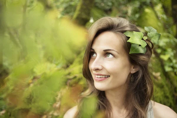 Mooi meisje met bladeren in het haar — Stockfoto