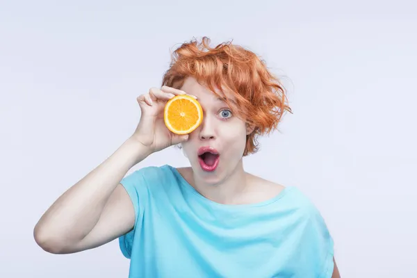 Emotional surprised beautiful woman with orange — Stock Photo, Image