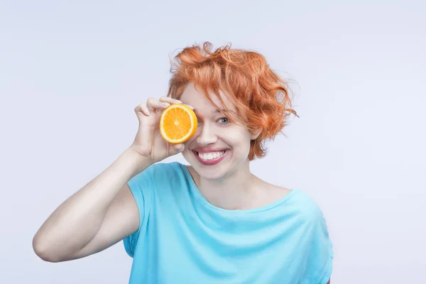 Lumineux souriant jeune femme avec orange — Photo