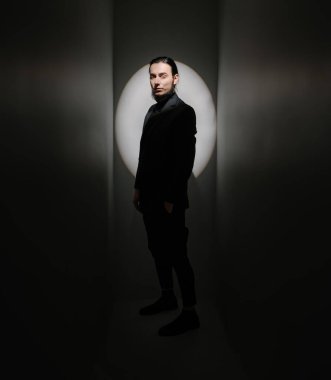 Karanlık taraf kişiliği. Uzun saçlı, takım elbiseli, sakallı zarif bir adam kibirli bir şekilde yan tarafa bakıyor. Şık bir egoist. Daire ışıkları. Gri renkler. Gevşek yarı kapalı gözler.. 