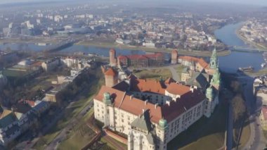 Hava aracı kameraları Wawel Kalesi 'nin çatısında uçuyor. Şehrin panorama 'sı, köprü ve nehir Vistula ve Grunwaldzki köprüsü şafak vakti güneş ışınları ve sis. Atmosferik güzel vide