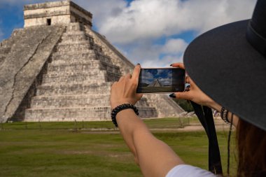 Kukulcn Tapınağı (El Castillo) Tinm Belediyesi, Yucatn Eyaleti. Meksika 'nın popüler turistik sitesinin fotoğrafını çeken bir kadın. Dünyanın en harika yerine gitmeli