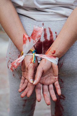 Savaş sırasında Ukrayna 'da şiddet ve zulüm. Savaş sırasında Ukrayna 'da tecavüz ve zulme karşı protesto gösterisi. Eller arkada bağlı, giysiler kanla kaplı. bir kurbanın taklidi 