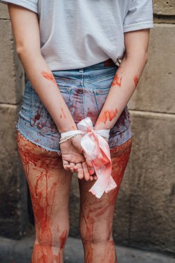 Kadın eylemcilerin Ukrayna 'da savaş sırasında tecavüze ve zulme karşı gösteri gösterileri. Eller arkada bağlı, giysiler kanla kaplı. Saldırıdan sonra kurbanın taklidi yapıldı.